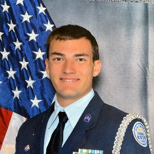 Student in uniform posing for portrait in front of the American flag